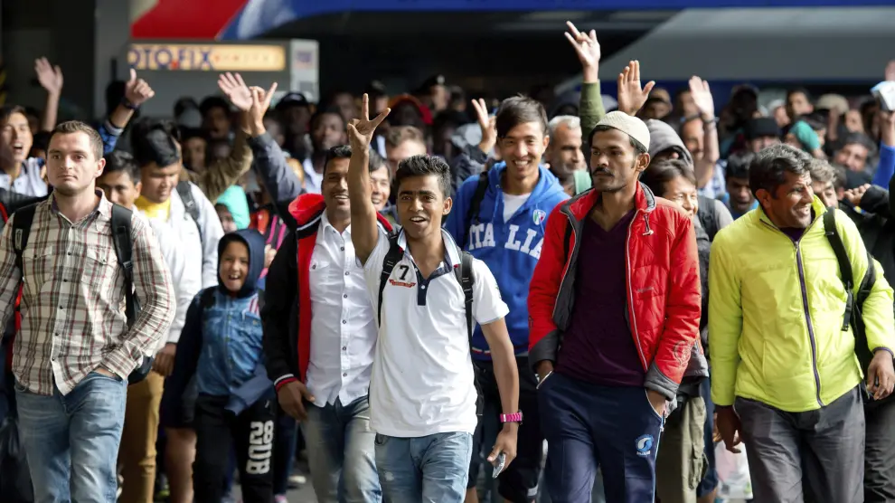 Varios refugiados saludan a su llegada a la estación de Munich.