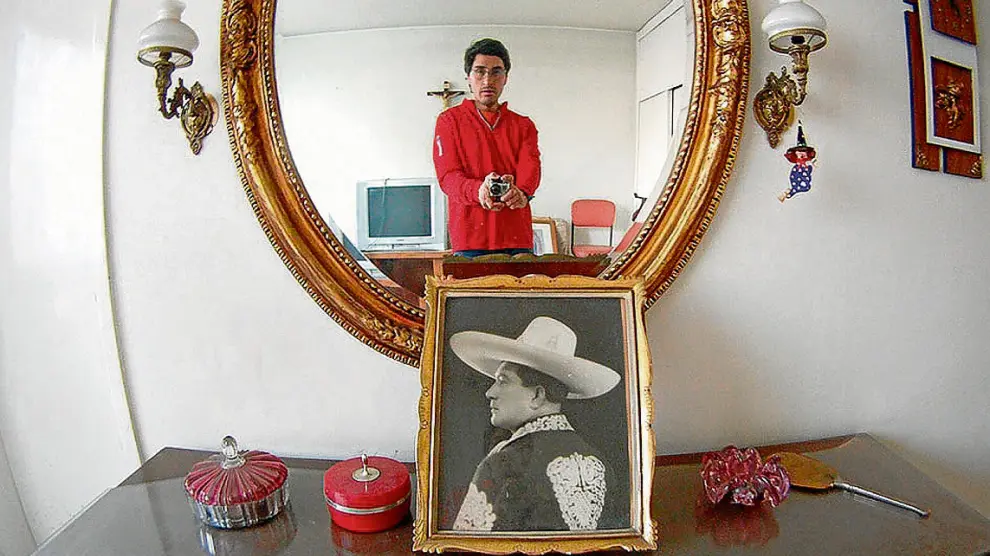 'Selfie' de Fernando Llanos (reflejado en un espejo), frente a la fotografía enmarcada de su abuelo.