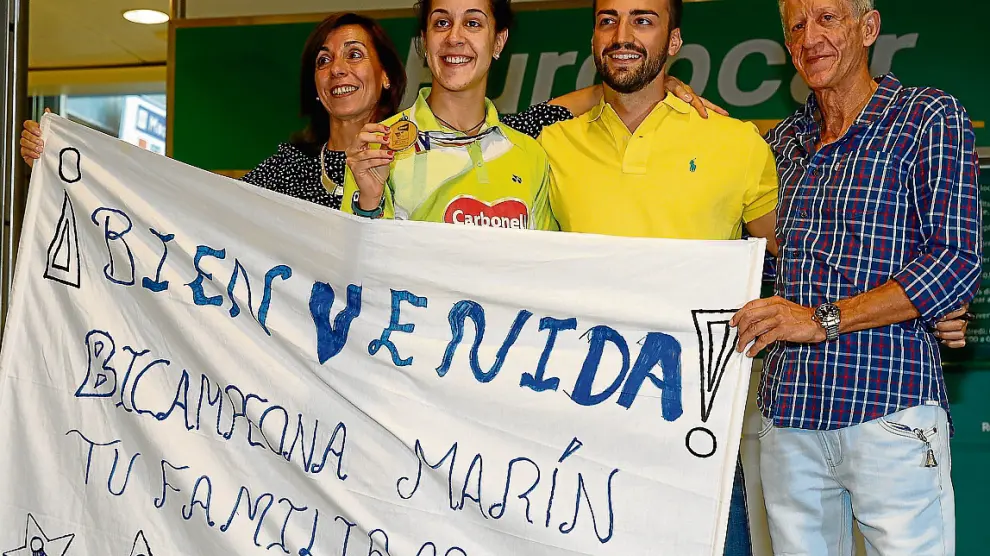 Carolina Marín, recibida ayer por sus padres y su pareja en el aeropuerto de Madrid.