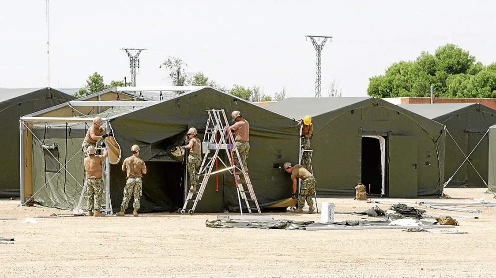 Miembros del grupo de apoyo de la OTAN montan las tiendas del cuartel general en la base.