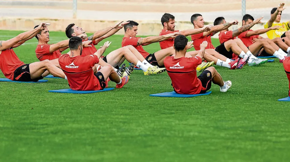 Los futbolistas del Real Zaragoza, en una singular imagen durante los estiramientos al final de un entrenamiento de la semana.