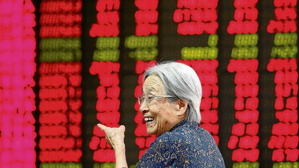 Una mujer sonríe al ver las cifras de la recuperación de la bolsa china, en Pekín.