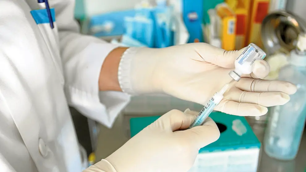 Una profesional sanitaria prepara una vacuna para su posterior inyección.
