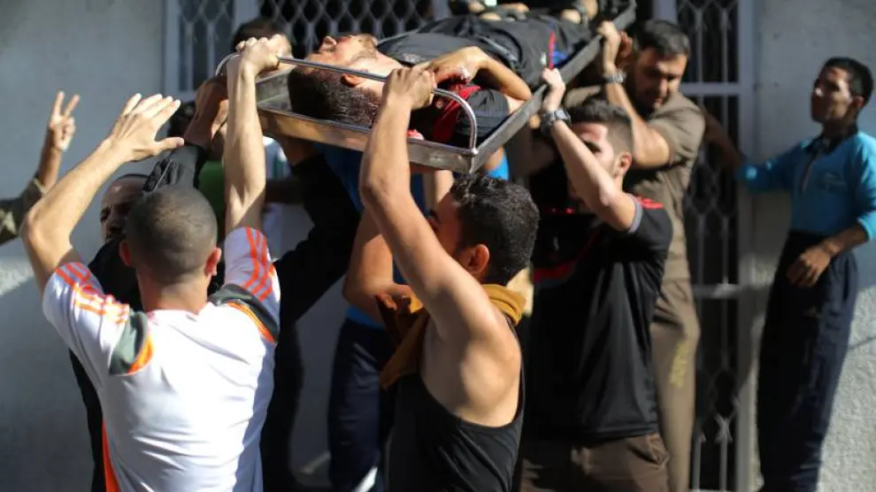 Un grupo de palestinos traslada a una víctima.