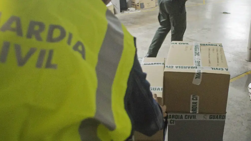 Agentes de la Guardia Civil transportan el material incautado en el registro al Ayuntamiento de Olot (Gerona).