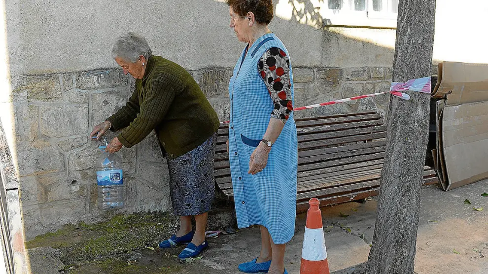 Dos vecinas de Bello llenaban ayer garrafas con agua procedente de la desnitrificadora.
