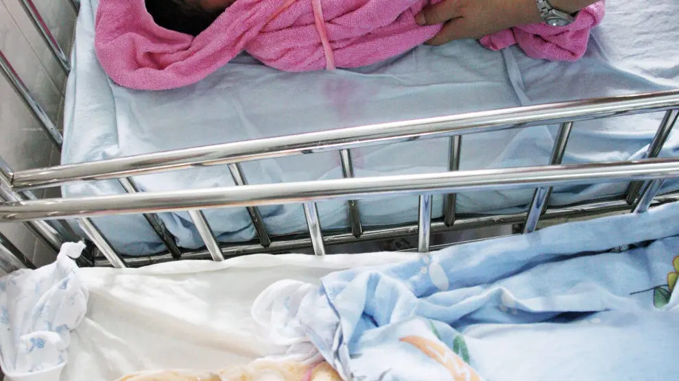 Una enfermera china atiende a dos bebés.