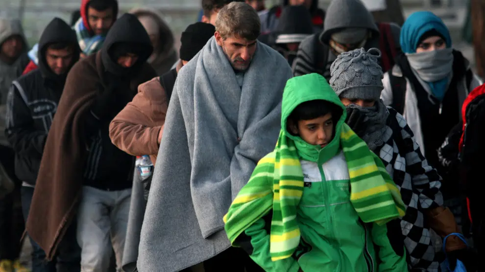 Refugiados caminan en la frontera de Macedonia y Grecia.