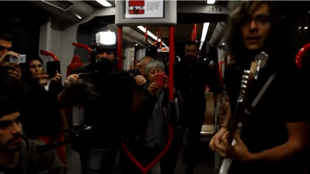 Varios pasajeros del tranvía hacen fotos al grupo musical Ultravioleta.
