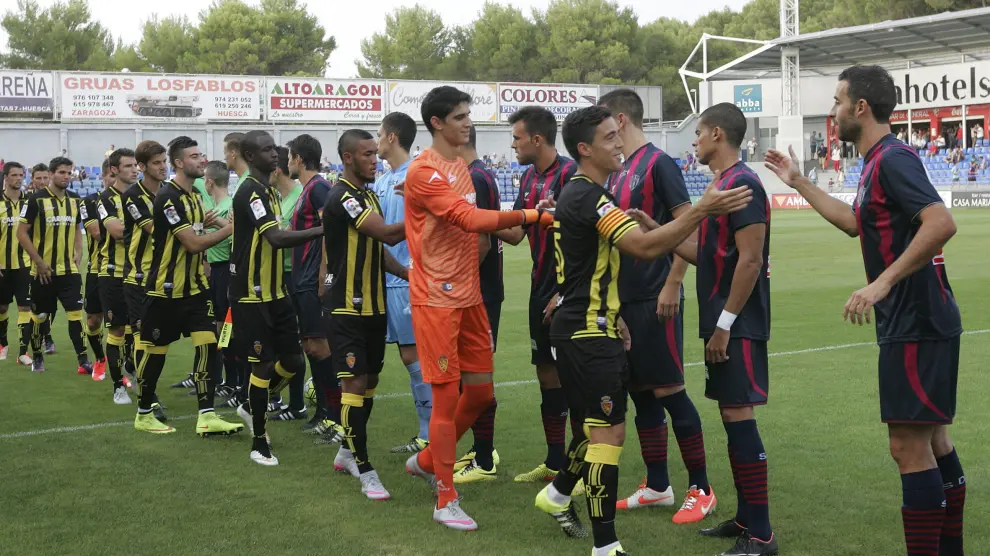 Los jugadores del Real Zaragoza y el Huesca se saludan, en el partido de pretemporada