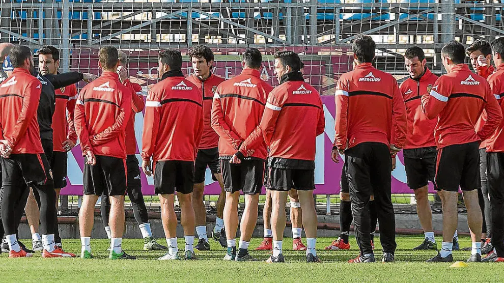 Los jugadores del Real Zaragoza rodean al cuerpo técnico en la charla previa al inicio del entrenamiento.