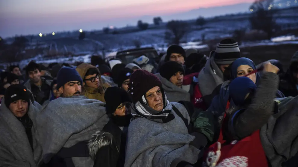 Refugiados cruzando la frontera entre Macedonia y Serbia este sábado.