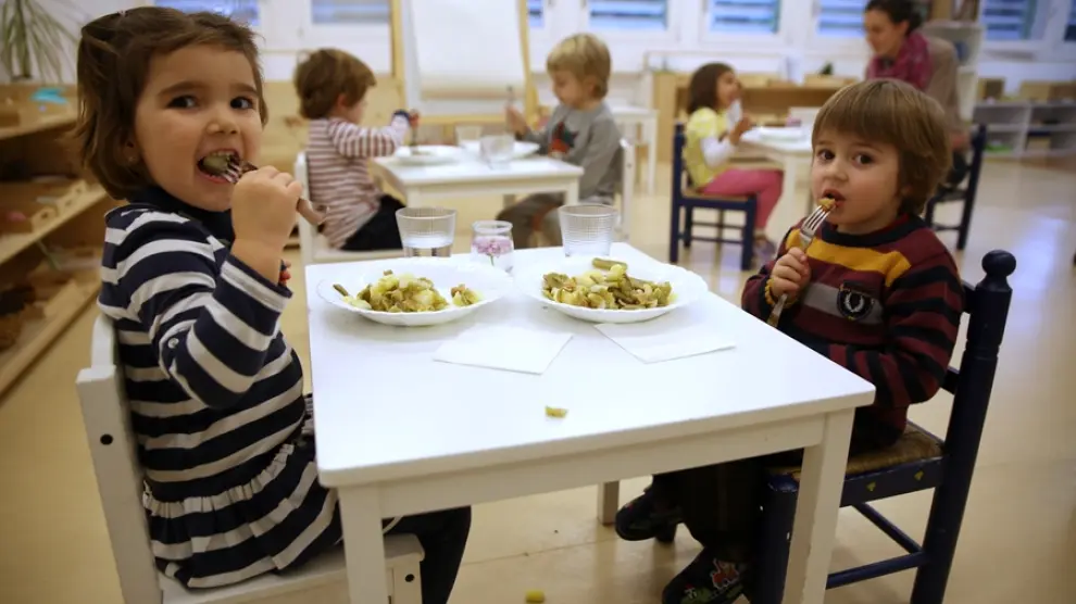 Los niños comen judía verde con patata y salteado de hamburguesa de espelta.