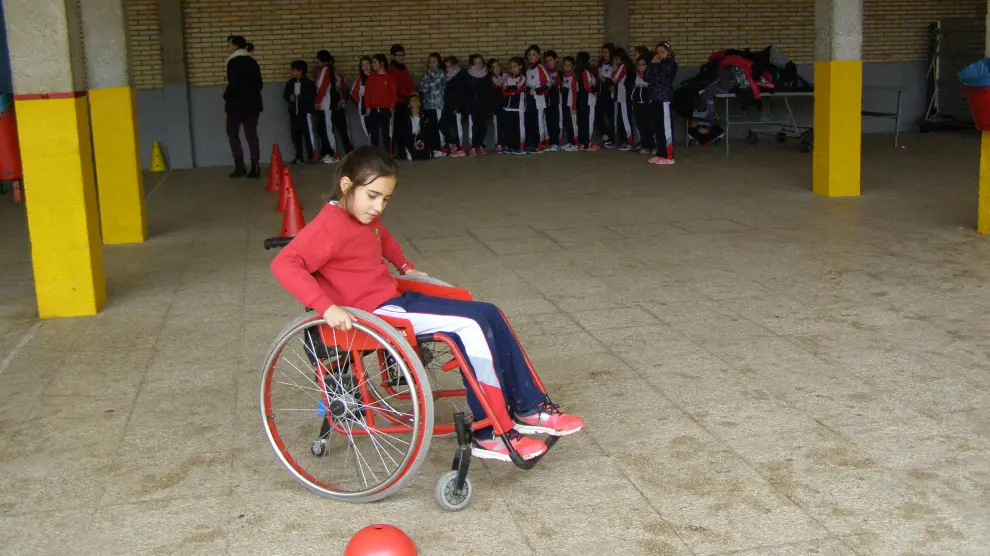 Una niña sortea un circuito de obstáculos en silla de ruedas.
