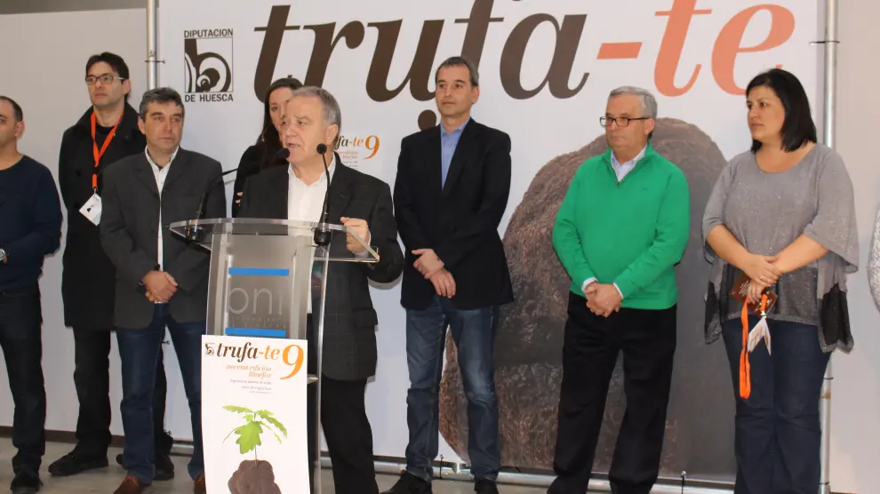 El presidente de la DPH, Miguel Gracia, rodeado por el alcalde de Binéfar, a su espalda, Alfonso Adán, y por los cocineros del certamen.