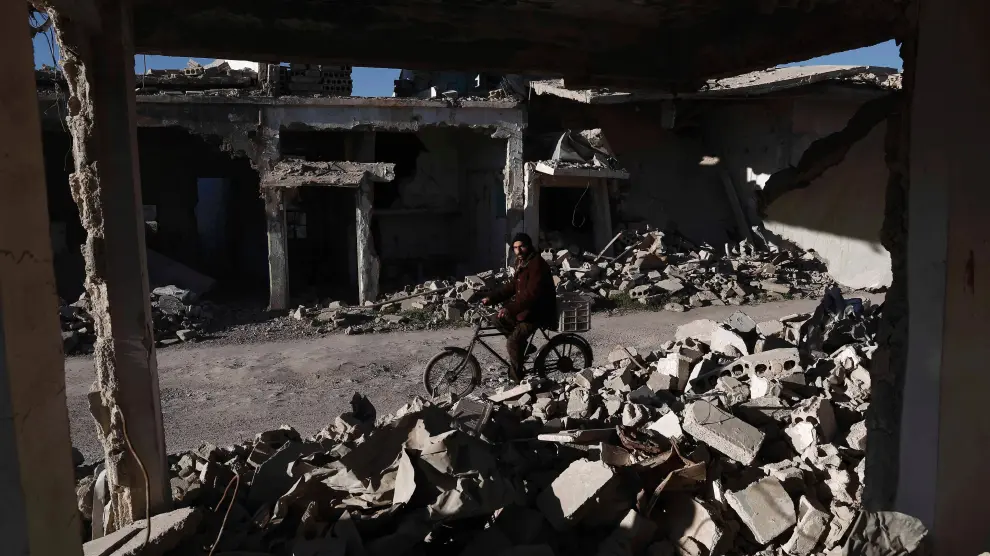 Un hombre pasa junto a un edificio derribado cerca de Damasco.