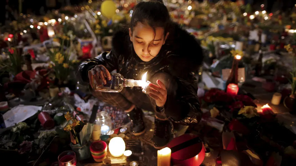 Una niña enciende una vela por las víctimas de los atentados del martes.