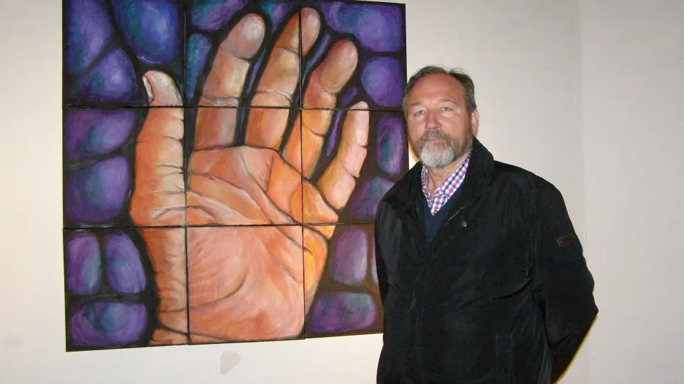Pie de foto: El pintor Carlos Gorrindo, junto a uno de sus cuadros expuestos.