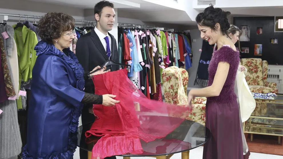 Voluntarios de Cáritas Huesca se visten de gala en la tienda 'Trobada Vintage' para mostrar las prendas a la venta.