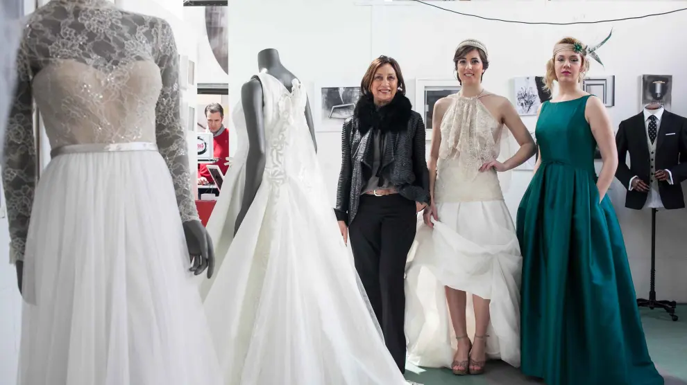 Elena Peiró, Cristina Alanís y Lorena Tormes, junto a algunos de los vestidos de novia que se mostraron.