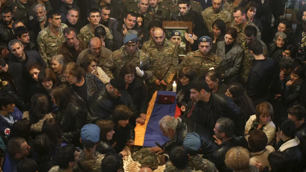 Decenas de personas rodean el féretro de un soldado armenio muerto.