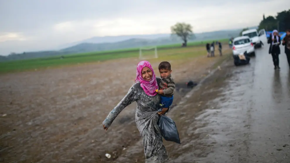 Una mujer refugiada camina en las afueras del campo de Idomeni, en Grecia