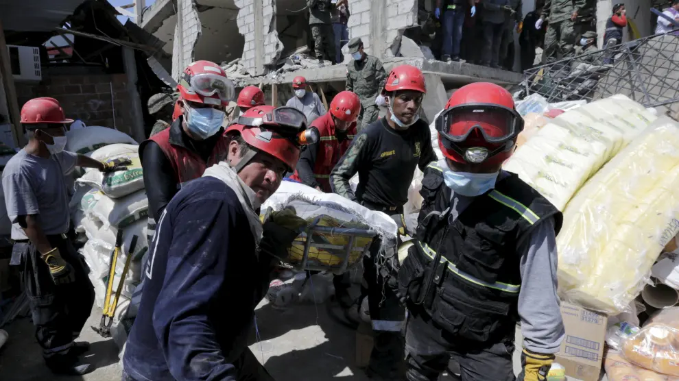 Miembros de los equipos de rescate trasladan a una víctima rescatada entre los escombros en Pedernales, Ecuador.