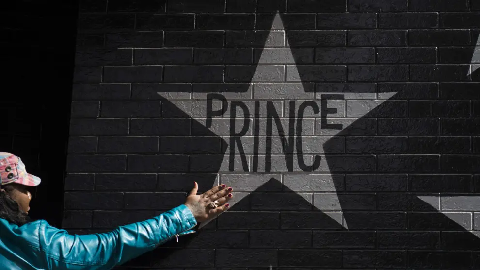 Una admiradora de Prince, ante un cartel con el nombre del artista.