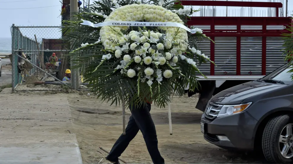 Un hombre sostiene un arreglo floral para uno de los fallecidos de la pasada explosión en México