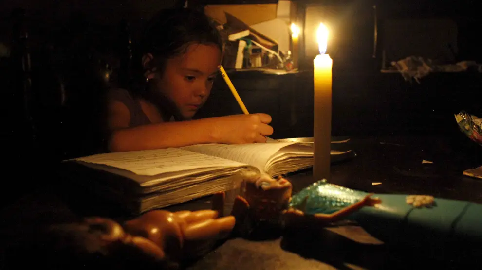Una niña hace sus deberes con una vela encendida a causa de un corte de electricidad en San Cristóbal, en el estado de Tachira.