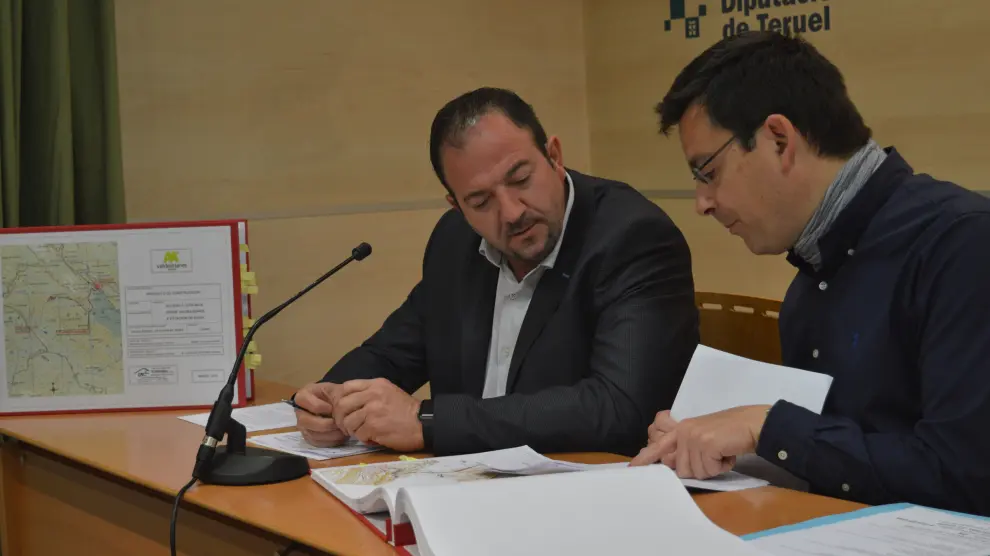 El presidente de la Diputación Provincial, a la izquierda, mira los planos que muestra el ingeniero jefe.