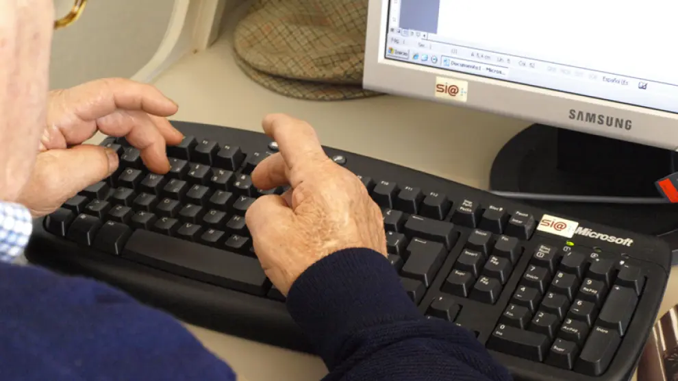 Un hombre mayor utiliza un ordenador.