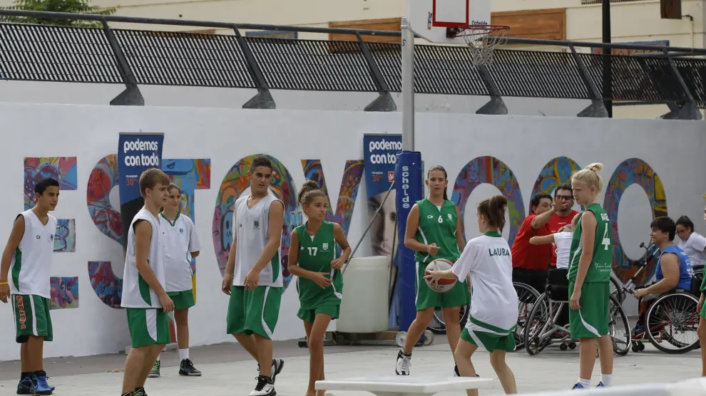 Un grupo de jóvenes juega a baloncesto en una cancha montada en la plaza del Pilar