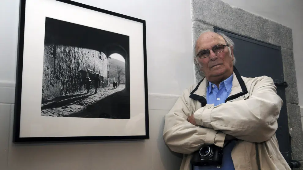 Carlos Saura posa junto a una de sus fotografías durante la inauguración de su exposición en Segovia.