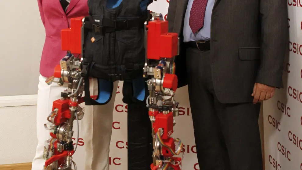 El presidente del CSIC, Emilio Lora, posa junto a la investigadora Elena García, que ha creado el exoesqueleto dirigido a niños con atrofia muscular espinal.