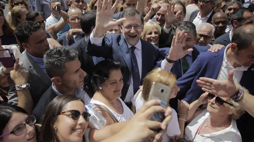 El presidente del Gobierno y líder del PP, Mariano Rajoy (c), saluda rodeado de personas durante un paseo por las calles de la localidad gaditana de Jerez de la Frontera