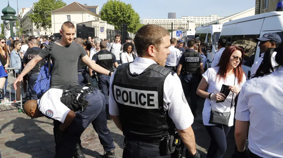 La policía francesa registra a varias personas junto a la zona de aficionados próxima a la Torre Eiffel de París.