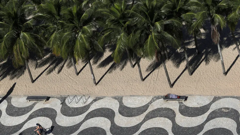 Un hombre duerme en una playa de Río de Janeiro.