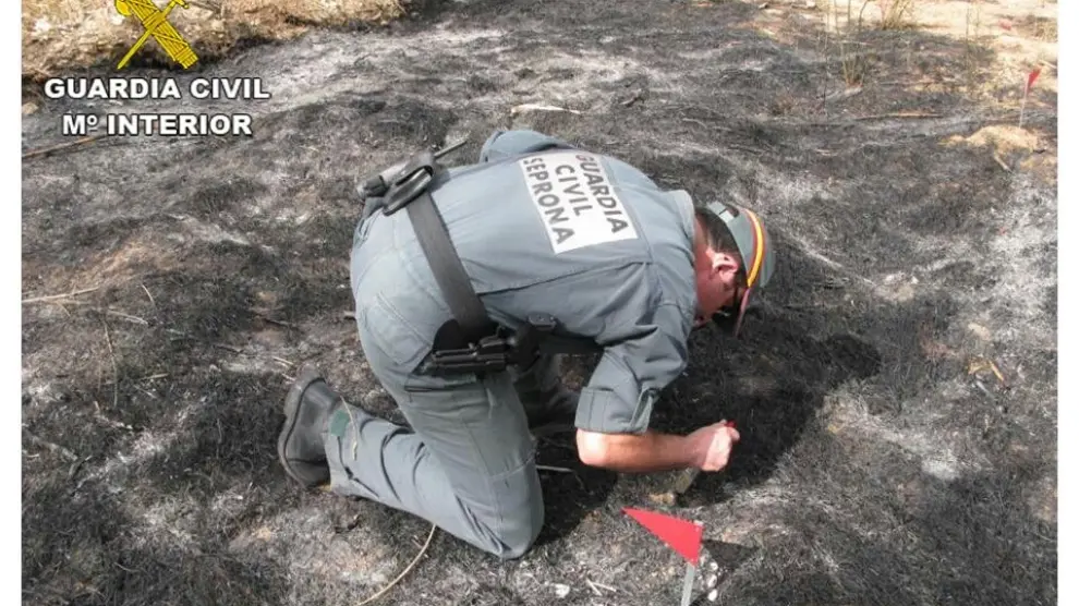 Un agente inspecciona el lugar en el que se produjo el incendio