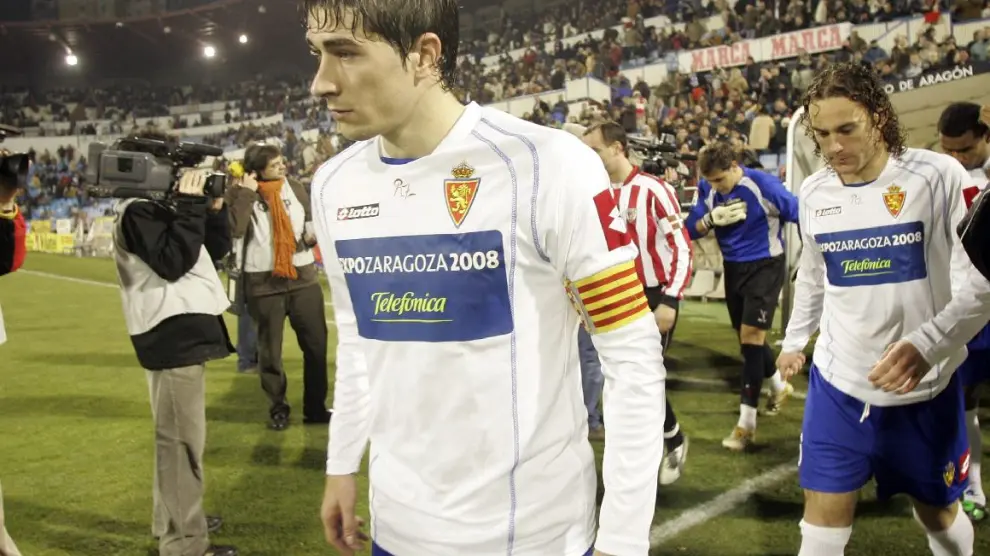Cani, capitán del Real Zaragoza, sale al campo por delante de Gaby Milito en un partido en La Romareda ante el Athletic de Bilbao en 2005