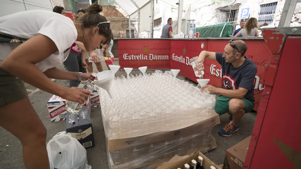 Peñistas voluntarios de El Trago preparan las garrafas con las que se refrescarán en la puesta del Pañuelico.