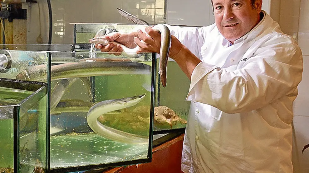 Ángel Muñoz, de pescados Muñoz Bailo, con algunos ejemplares de anguila en su establecimiento.