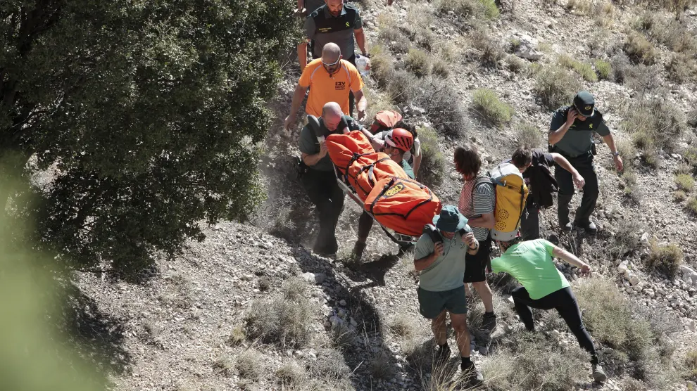El equipo de rescate transporta el cadáver del excursionista fallecido en una camilla tras ser rescatado del río.
