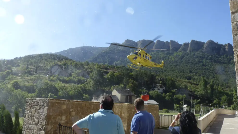 Vecinos de Santa Cruz de la Serós miran cómo los helicópteros cogen agua en las piscinas.