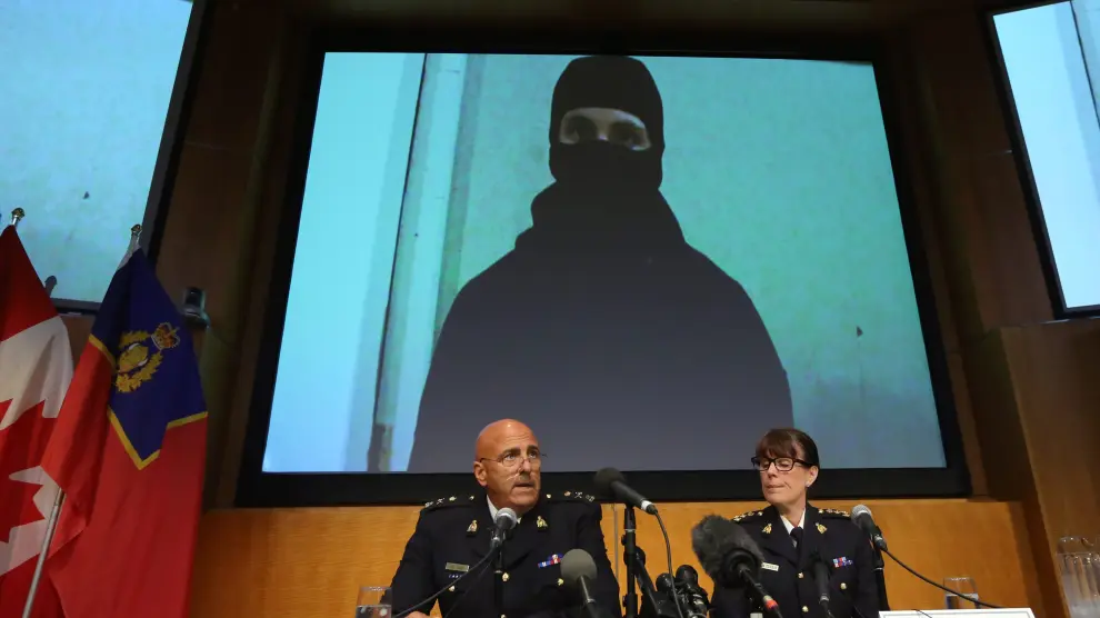Los portavoces de la Policía Montada explican la operación con una imagen del vídeo del terrorista de fondo