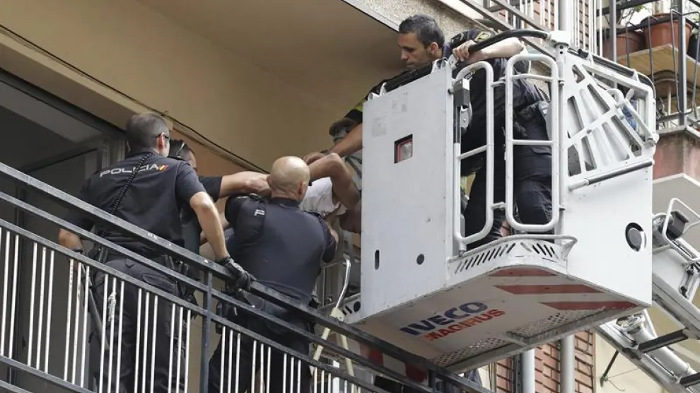 Efectivos de la Policía Nacional sacan de la vivienda por una escalera de Bomberos a uno de los jóvenes que han sido detenidos en Salamanca