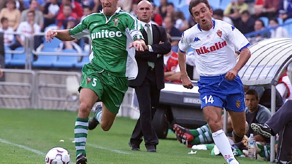 Luis César Sampedro, en segundo término delante de su banquillo en La Romareda, el 6 de octubre de 2002 en un Real Zaragoza-Racing de Ferrol. Juanele intenta desbordar al defensor gallego.