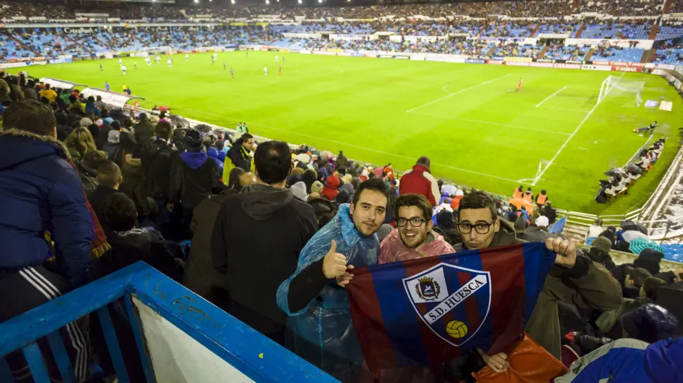 Tres aficionados del Huesca posan en La Romareda en el último derbi