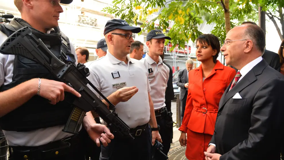 El ministro de interior francés Bernard Cazeneuve y la ministra de educación Najat Vallaud-Belkacem hablan con los policías que vigilan un escuela