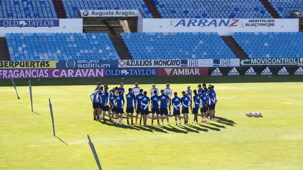 La plantilla del Real Zaragoza, reunida en el centro del campo de La Romareda, donde reciben al Alcorcón, en el entrenamiento de este viernes.
